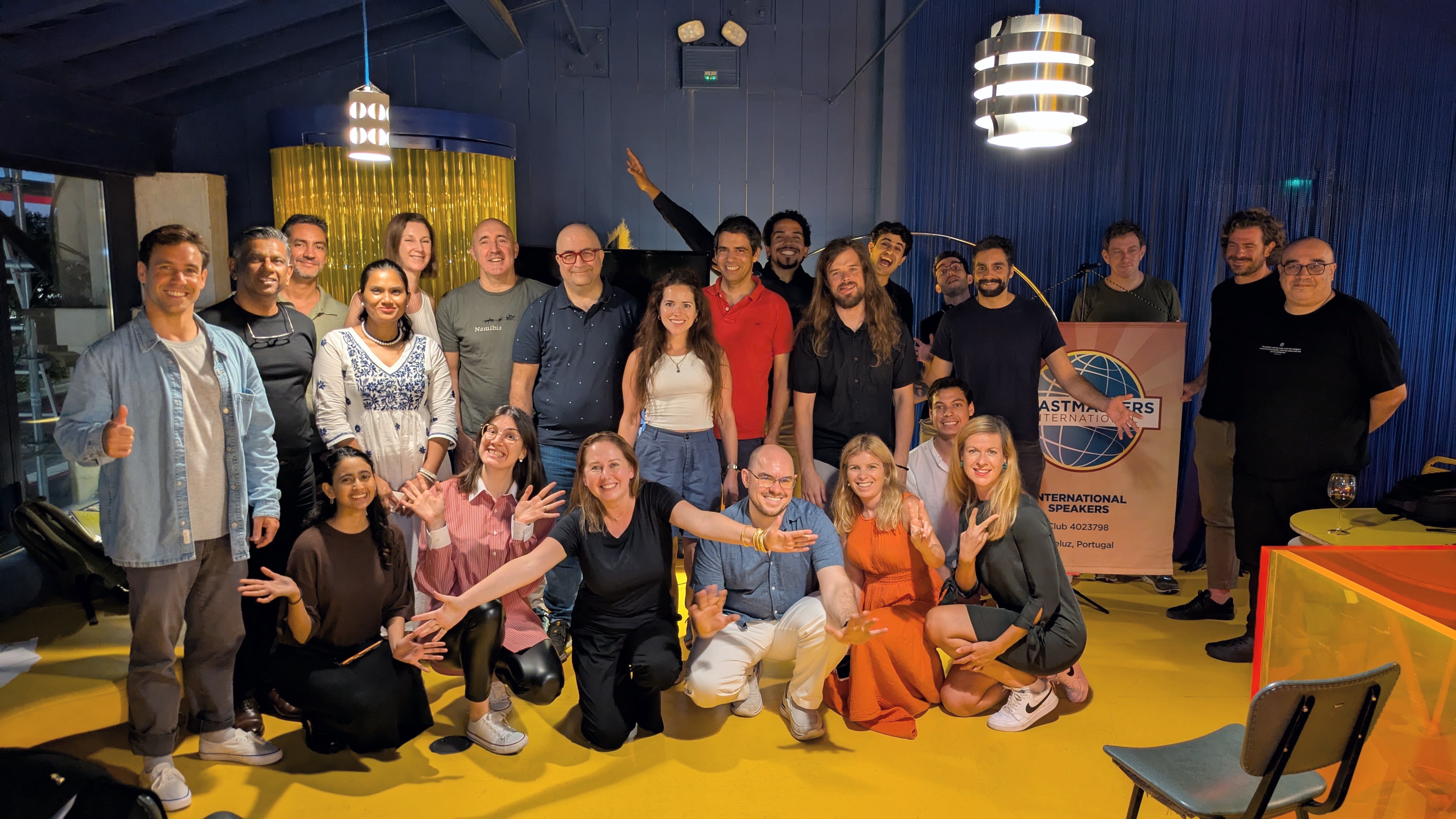 Club members smiling beside the Toastmasters banner
